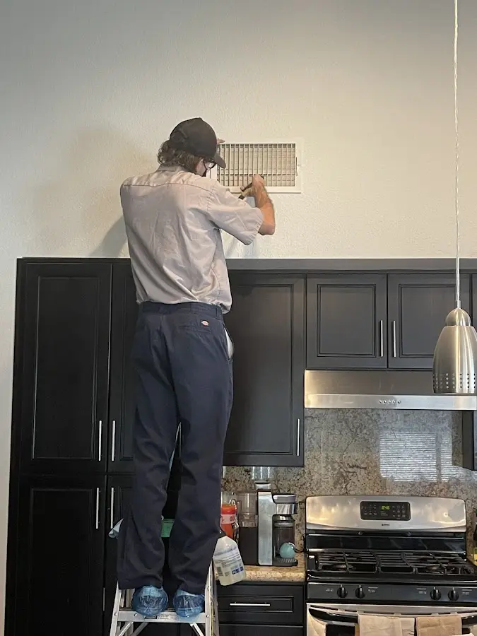 Technician inspecting an air vent during HVAC service in Dothan